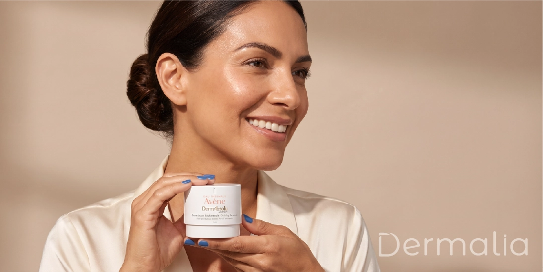 Mujer sosteniendo crema Avène DermAbsolu como parte de una rutina anti edad para mejorar firmeza y luminosidad.