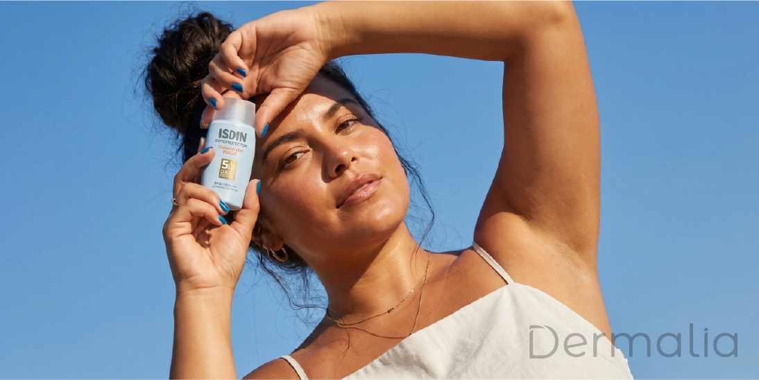 ISDIN Fusion Water SPF 50+ para piel grasa y mixta Mujer sosteniendo protector solar ISDIN Fusion Water SPF 50+ con textura ultraligera y acabado mate